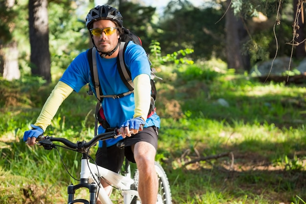 Retrato de hombre ciclista de montaña con bicicleta en el bosque