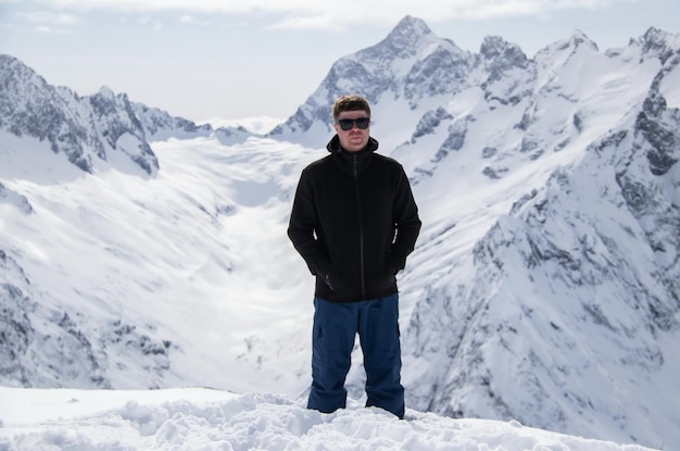 Retrato de un hombre en la cima de una montaña nevada.