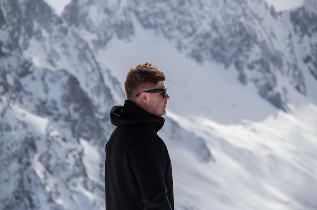 Retrato de un hombre en la cima de una montaña nevada.