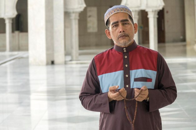 Foto retrato de un hombre con un collar de pie en una mezquita