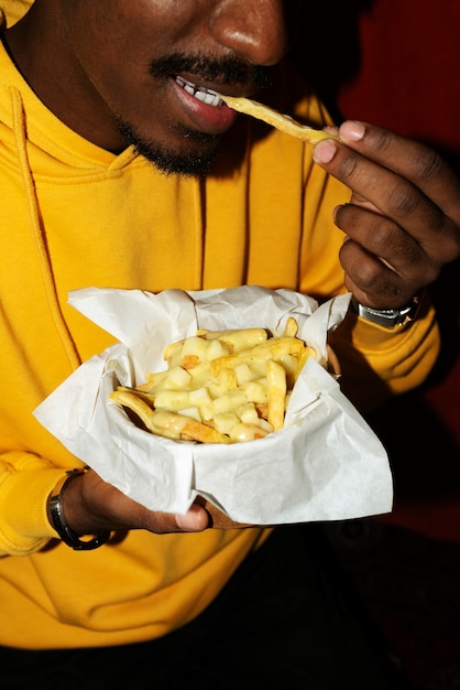 Foto retrato de hombre comiendo un delicioso plato de poutine