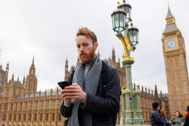 Retrato de un hombre concentrado con un teléfono inteligente en las manos