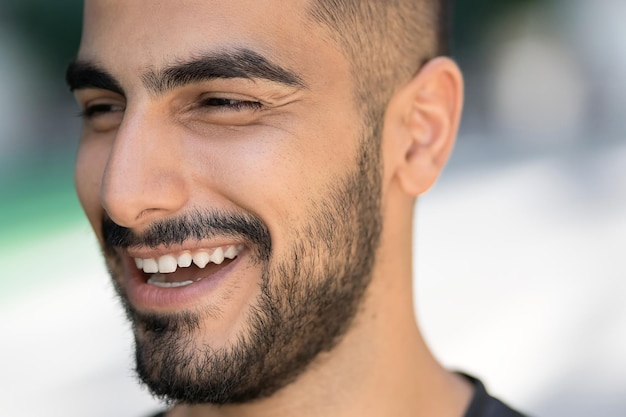 Retrato de un hombre confiado iraní feliz riendo y mirando a distancia