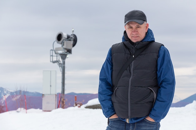 Retrato de un hombre contra las montañas. Generador de nieve