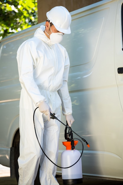 Retrato de hombre de control de plagas de pie junto a una camioneta