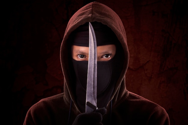 Retrato de un hombre con un cuchillo contra la pared