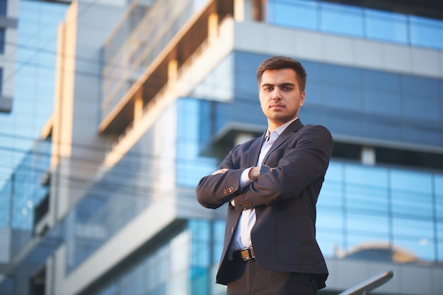 Retrato de un hombre en una demanda contra el edificio con fachada de vidrio