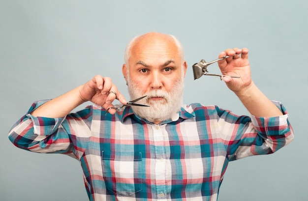 Foto retrato de un hombre elegante con barba y bigote gris con barba y tijeras y cortapelos rectos