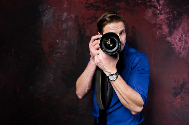 Retrato de hombre elegante fotógrafo profesional con cámara, usar en camisa azul y corbata.