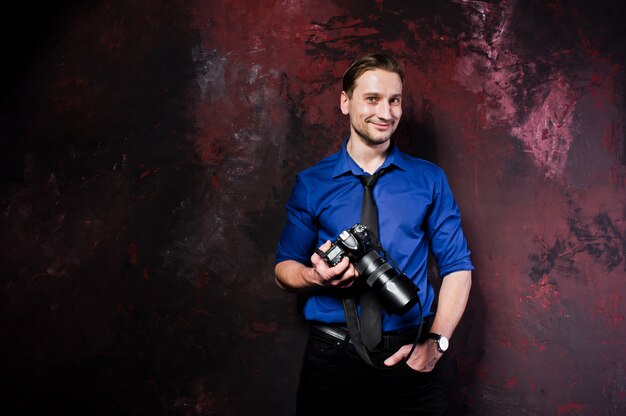 Retrato de hombre elegante fotógrafo profesional con cámara, usar en camisa azul y corbata.