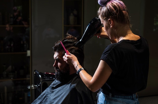 Retrato de hombre elegante y maestro peluquero con tijeras y barbería de cepillo