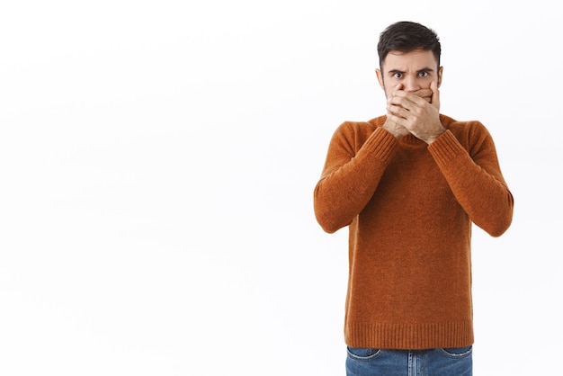 Retrato de un hombre enfermo y cansado caucásico enojado que se cubre la boca y expresa enojo con los ojos se niega a hablar exige libertad de expresión de pie angustiado y molesto de fondo blanco