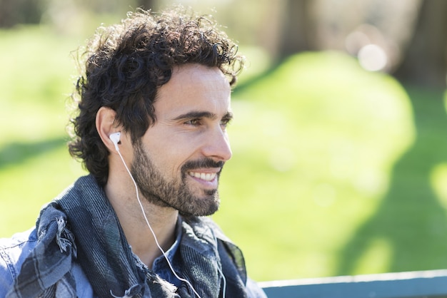 Retrato de un hombre escuchando música al aire libre