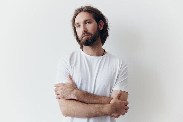 Retrato de un hombre con una espesa barba negra y pelo largo en una camiseta blanca sobre un fondo blanco aislado estilo de vida sin patetismo imagen cotidiana