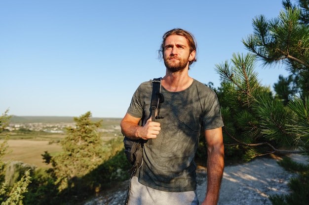 Foto retrato de un hombre excursionista con mochila en las montañas