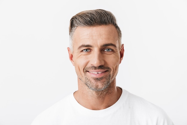 Retrato de hombre exitoso de 30 años con cerdas vistiendo camiseta casual sonriendo aislado en blanco