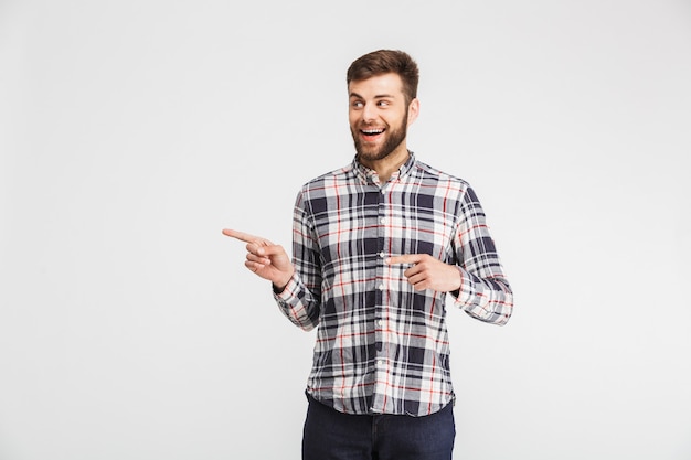 Retrato de un hombre feliz apuntando con el dedo lejos