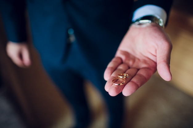 Retrato de un hombre feliz guapo vestido con esmoquin con caja abierta con un anillo de compromiso.