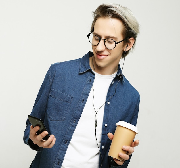 Retrato de hombre feliz hablando por teléfono y bebiendo café