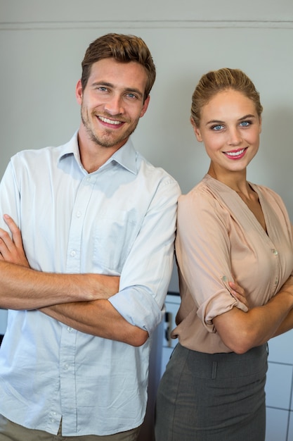 Retrato de hombre feliz y mujer de pie en la oficina