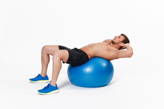 Retrato de un hombre fitness haciendo ejercicios de estiramiento en el gimnasio