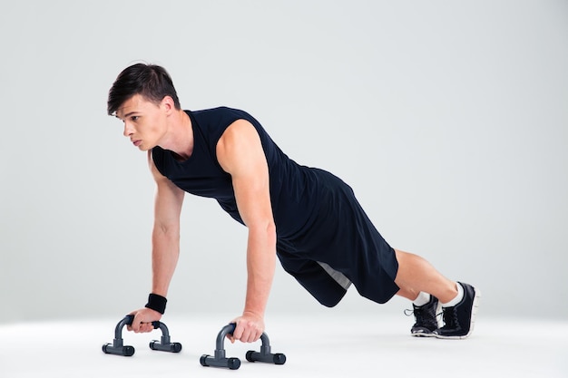 Retrato de un hombre de fitness haciendo flexiones aislado