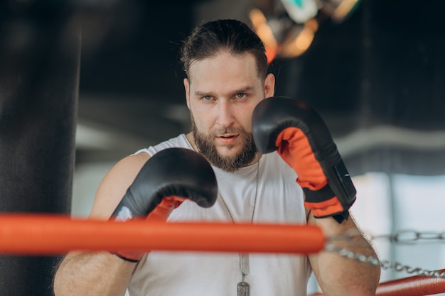 Retrato de hombre fuerte en el ring de boxeo mirando a la cámara