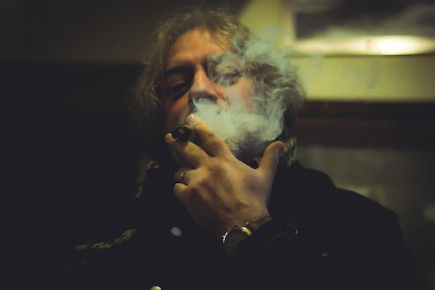 Foto retrato de un hombre fumando un cigarro