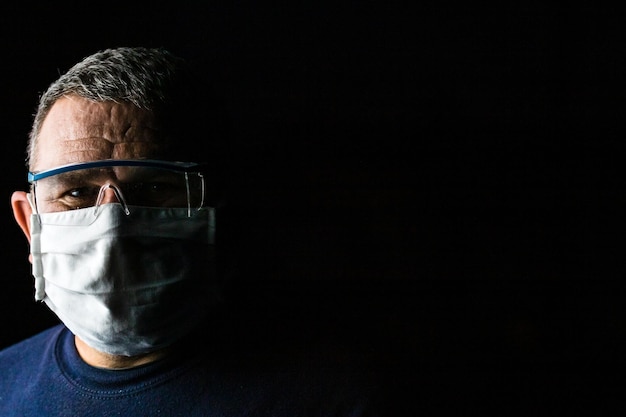 Foto retrato de un hombre con gafas contra un fondo negro