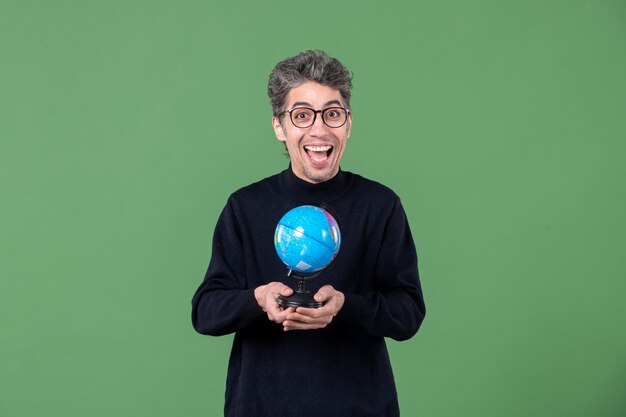 retrato de hombre genio sosteniendo pequeño globo terráqueo foto de estudio fondo verde naturaleza planeta espacio maestro