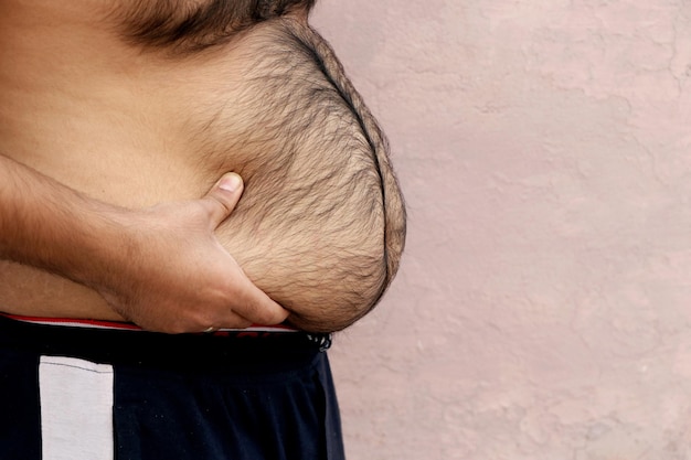 Un retrato de un hombre gordo asiático muestra su cuerpo y su gran barriga. Concepto de obesidad