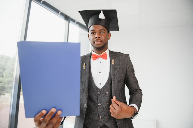 Retrato de hombre de graduación con diploma.