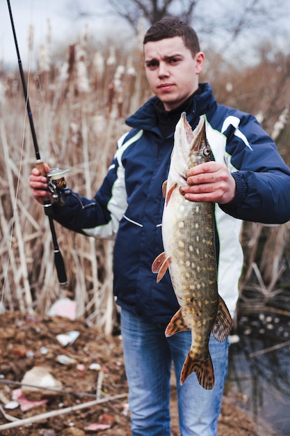 Foto retrato de hombre con grandes peces capturados y caña de pescar