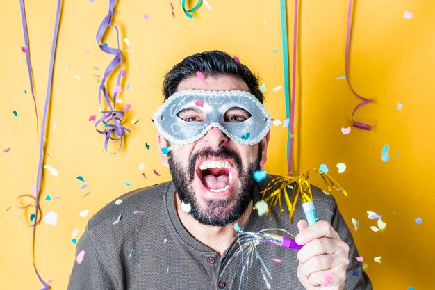 Foto retrato de un hombre gritando mientras lleva una máscara durante una fiesta