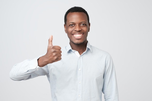 Retrato de hombre guapo afroamericano feliz riendo y mostrando el pulgar hacia arriba