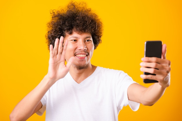 Retrato hombre guapo asiático pelo rizado tomando selfie con smartphone