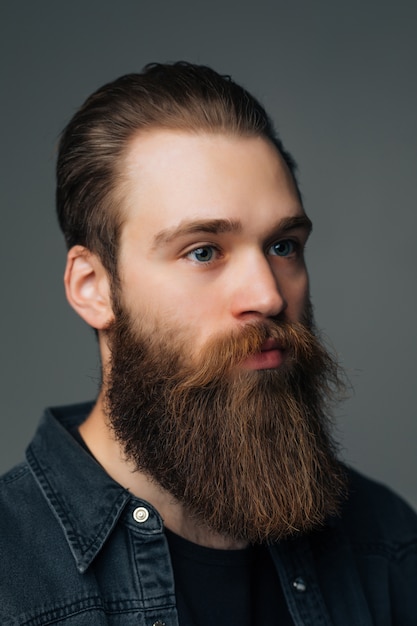 Retrato de hombre guapo con barba aislado sobre fondo gris