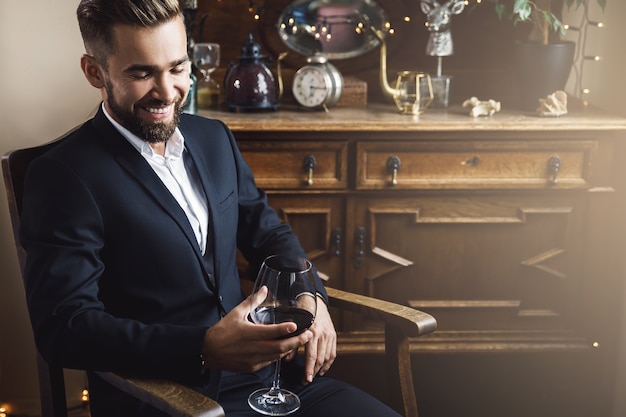 Retrato de hombre guapo con barba con una copa de vino tinto