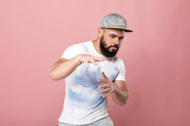 Retrato de hombre guapo con barba en gorra bailando