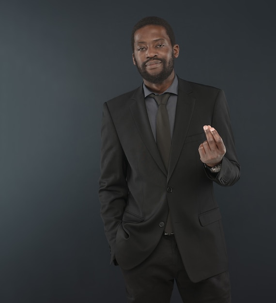 Retrato de hombre guapo con barba de mediana edad. Hombre afro vestido con una camisa color carbón, sebo negro con corbata está planteando