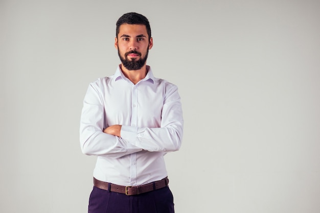 Retrato de hombre guapo con barba negra con ojos marrones en el estudio sobre un fondo blanco.