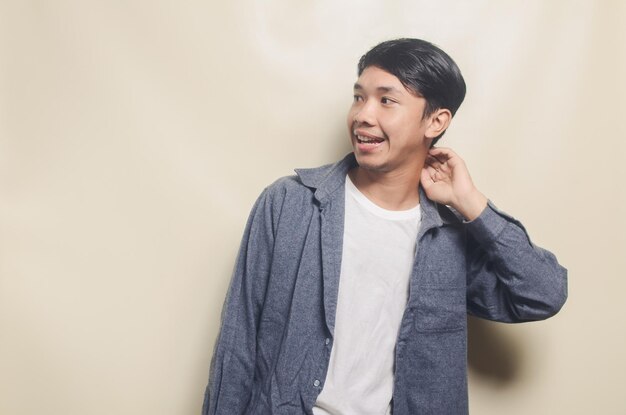 Retrato de hombre guapo con camisa gris mirando el espacio vacío