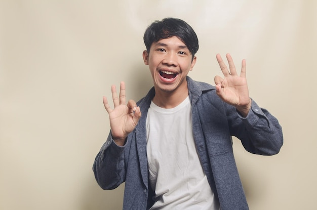 Retrato de un hombre guapo con camisa gris que muestra una expresión aceptable