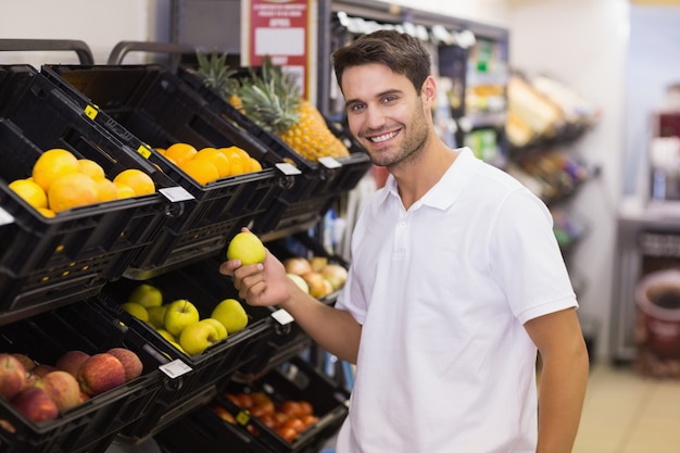 Retrato de un hombre guapo comprando frutas