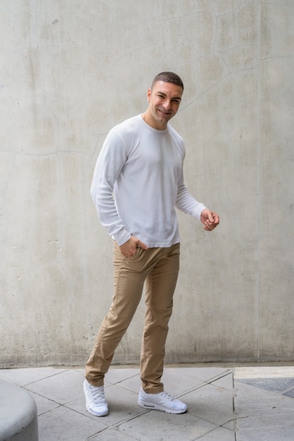 Foto retrato de hombre guapo contra el muro de hormigón al aire libre