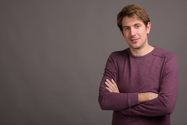 Retrato de hombre guapo contra la pared gris