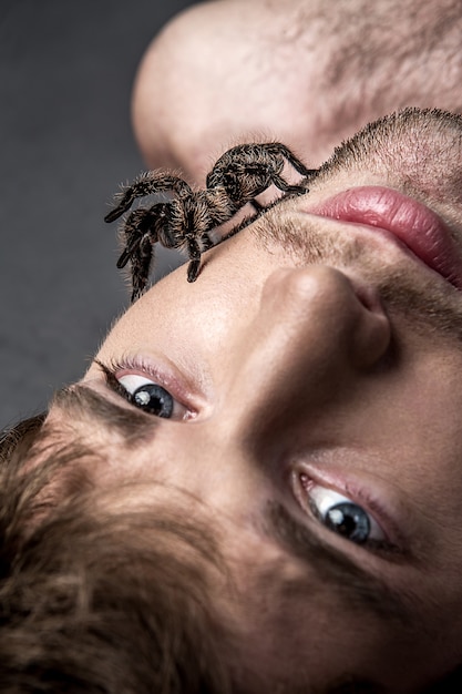 Retrato de un hombre guapo joven con la araña en su cara