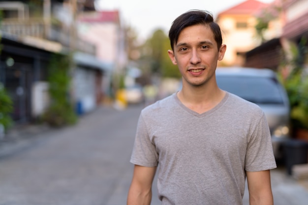 Foto retrato de hombre guapo joven feliz sonriendo al aire libre