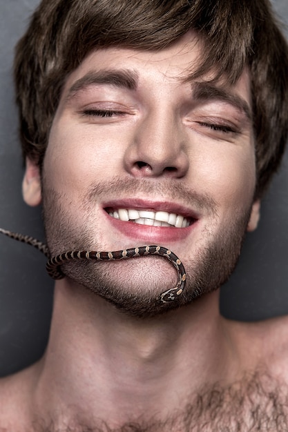 Retrato de un hombre guapo joven con la serpiente en su cara