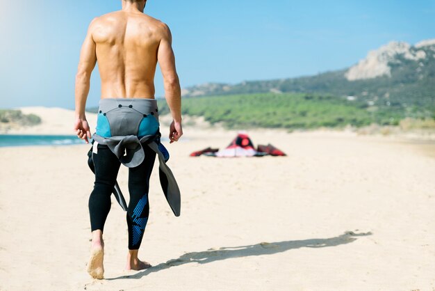 Retrato de hombre guapo kitesurfer en la playa.